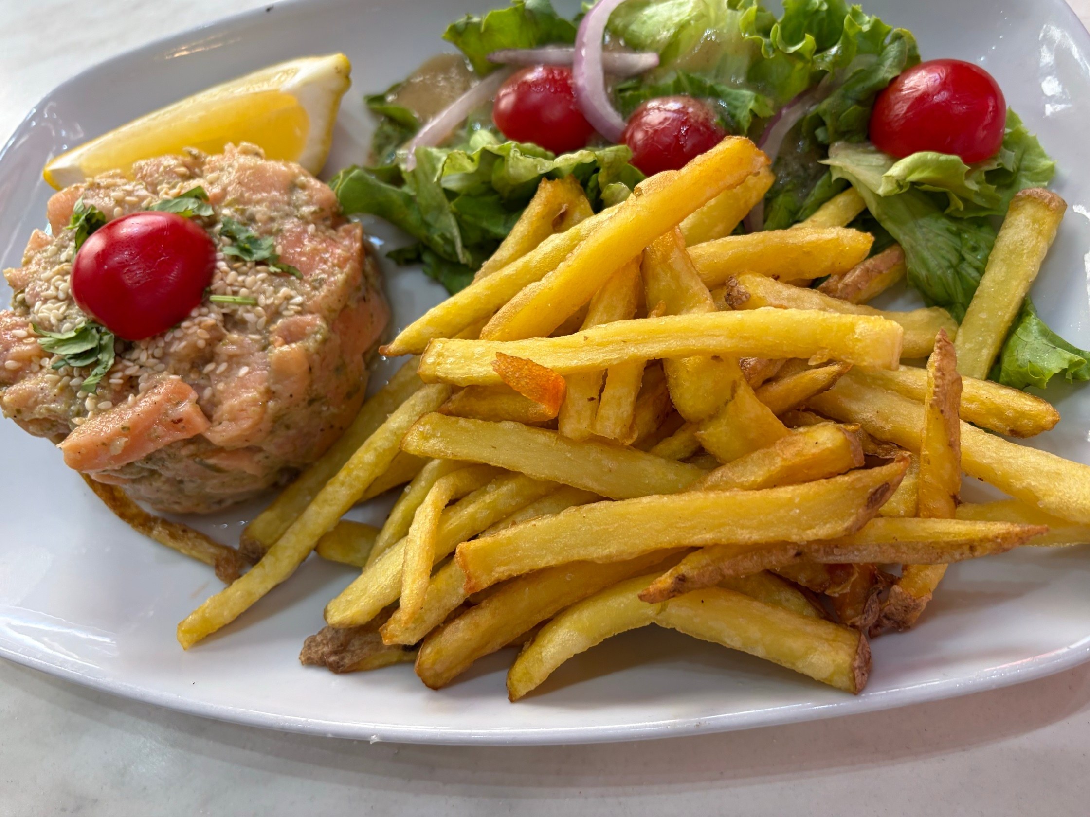 Tartare de saumon, frites et salade servis au Régent
